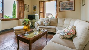 A cozy living room with a beige sofa, a wooden coffee table, and a TV. - Giuggiolo - Giuggiolo 5 by Interhome (Poggibonsi)