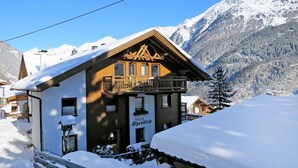 A wooden chalet with a balcony, surrounded by snow-covered mountains. - Alpenblick by Interhome (Sölden)