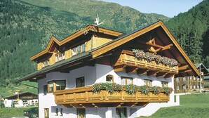 A chalet-style building with a wooden balcony, large windows, and a mountain backdrop. - Anemone by Interhome (Sölden)