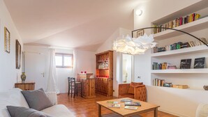 Un salon chaleureux avec un canapé, une table basse et une bibliothèque remplie de livres.