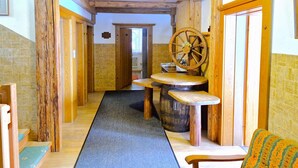 Ein Holzkamin mit einem Holztisch in der Mitte, einem Fass und einem Wagenrad.