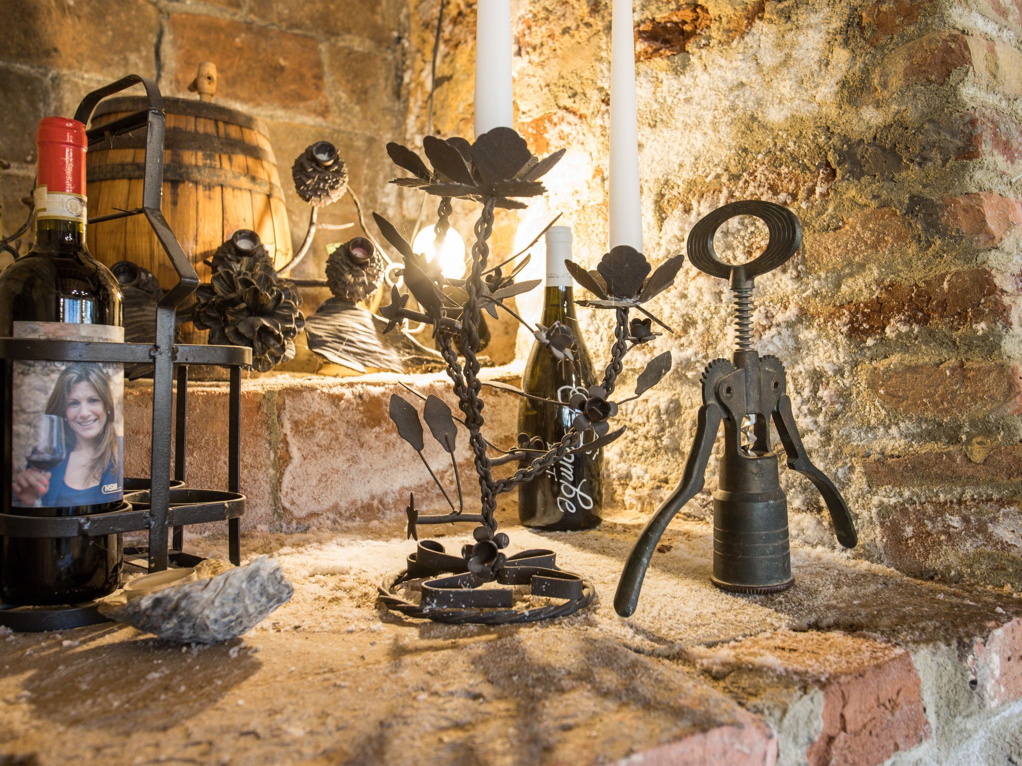 A rustic cellar with a wine barrel, a wine bottle, and a vintage corkscrew.