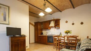 Un espacio habitable compacto con kitchenette, comedor y sofá.