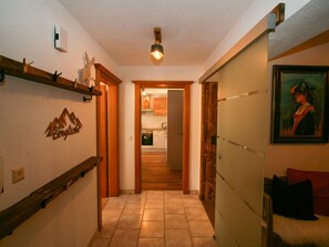 Enter a cozy space with a kitchen area visible through the doorway, featuring a stove, oven, and cabinets.