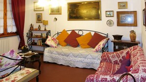 A traditional room with a bed, a chair, a table, and a bookshelf. - Castagni II (OCT101) by Interhome (Orciatico)