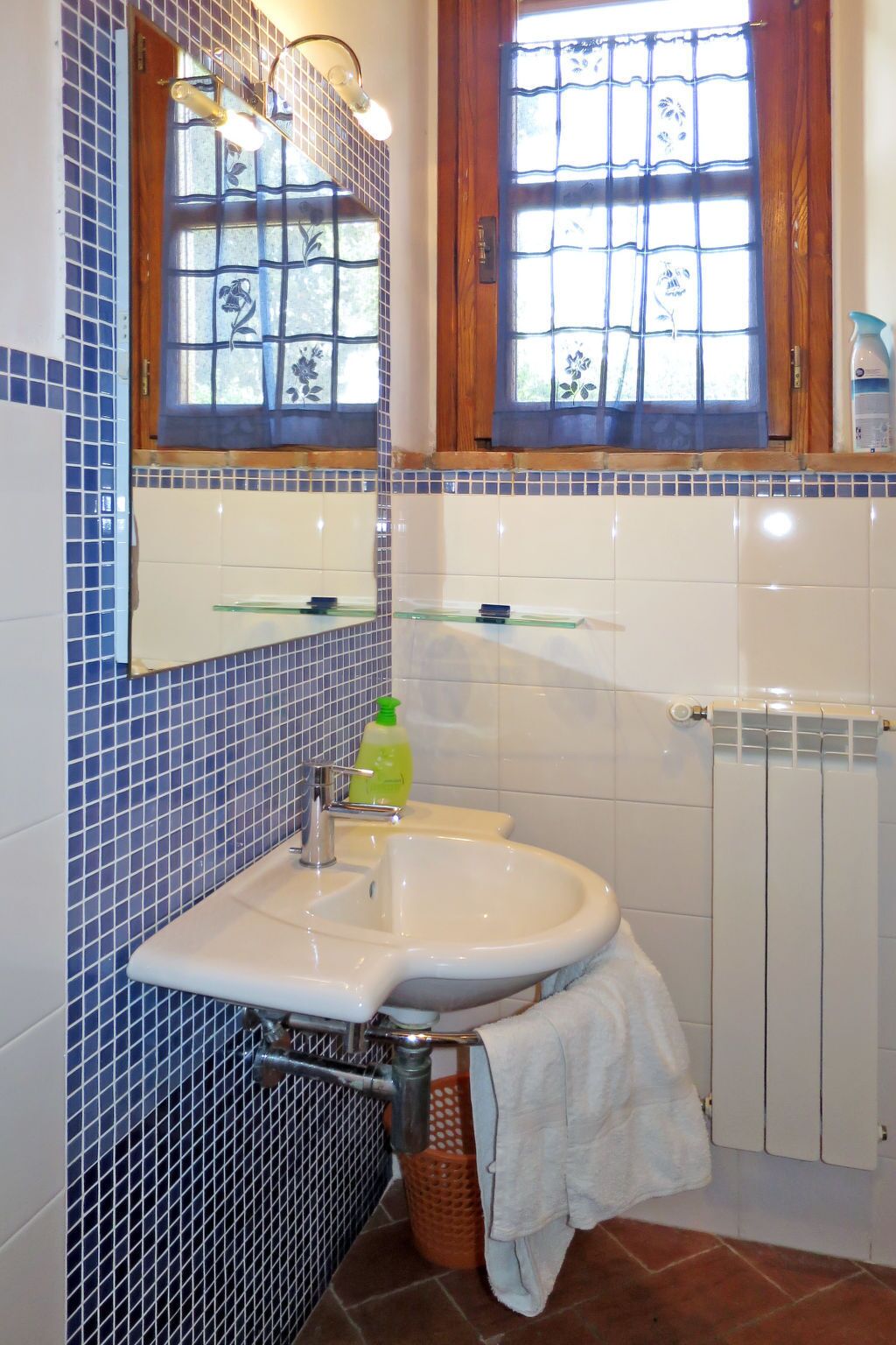 Ein Badezimmer mit Waschbecken, Spiegel und Fenster.