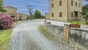 Un bâtiment en pierre avec une allée en gravier et un mur en briques.