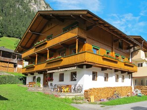 A traditional wooden chalet with a balcony, a stone wall, and a mountain backdrop. - Rieplerhof by Interhome (Mayrhofen)
