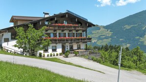 A traditional chalet with a balcony adorned with flowers, set against a mountainous backdrop. - Apart Vorwies by Interhome (Fügen)