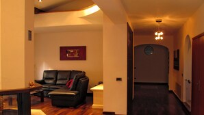 A modern living room with a leather sofa, a coffee table, and a television on a stand. - Natalie (BLU170) by Interhome (Bagni di Lucca)
