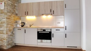 A compact kitchen with wooden cabinets, a Bosch oven, and a built-in refrigerator. - Theresia by Interhome (Alpbach)