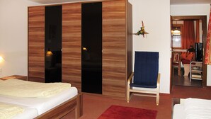 A hotel room with a bed, a chair, a wardrobe, and a small table. - Theresia by Interhome (Alpbach)
