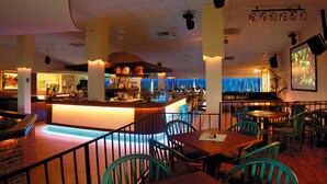 Un espace bar avec un comptoir, des sièges et un écran de projection.