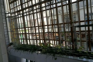 Une fenêtre avec des barreaux en métal et une jardinière en dessous.