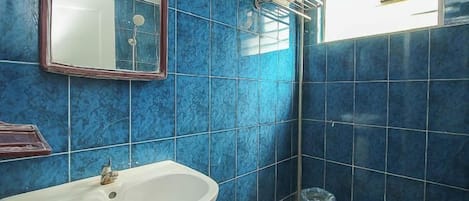 Un baño con lavamanos, espejo y retrete.