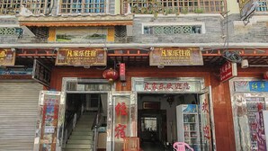 Un edificio tradicional con varias fachadas, incluyendo una entrada visible y una escalera que lleva al interior.