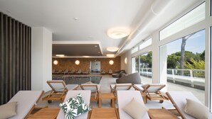 A modern indoor pool area with lounge chairs and a view of the outside. - Ca' Del Pioppo by Interhome (Cavallino)