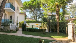 A residential building with a pool, surrounded by trees and a well-maintained lawn. - Elisabeth by Interhome (Lignano Pineta)