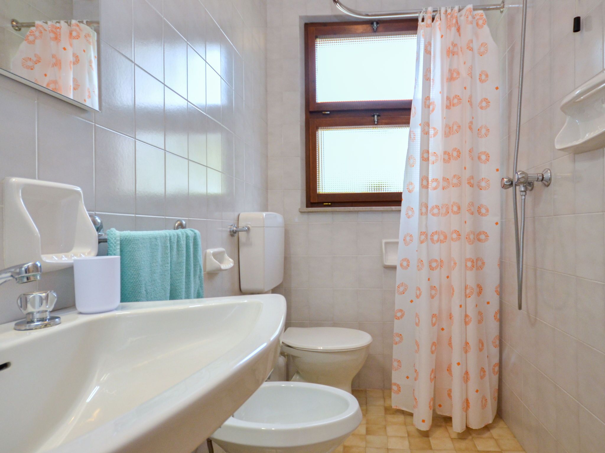 Une salle de bain équipée d’un lavabo, de toilettes et d’un rideau de douche.