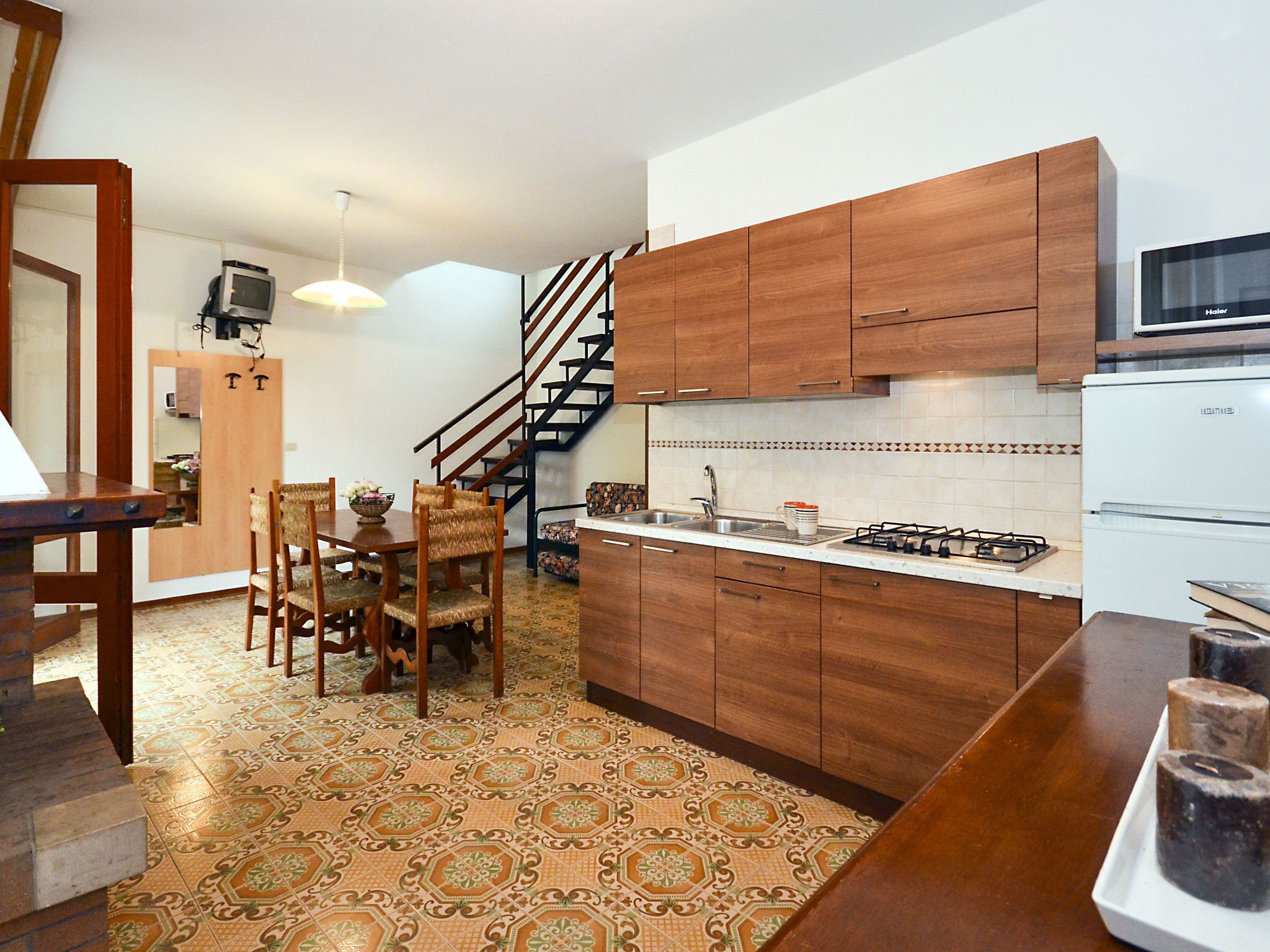 A compact kitchen with wooden cabinets, a gas stove, and a microwave.