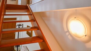 Een houten trap met een witte muur en ingebouwde planken.