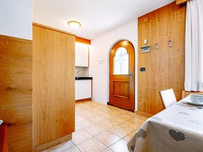 Eine kleine Küche mit Holzausstattung, einem Spülbecken und einem Fenster mit dekorativer Glasscheibe.