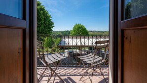 Un balcon donnant sur un parc et sur des bâtiments situés au loin.