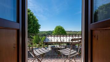 Un balcon donnant sur un parc et sur des bâtiments situés au loin.
