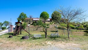 Un parc avec une aire de jeux, des bancs et un bâtiment en arrière-plan.