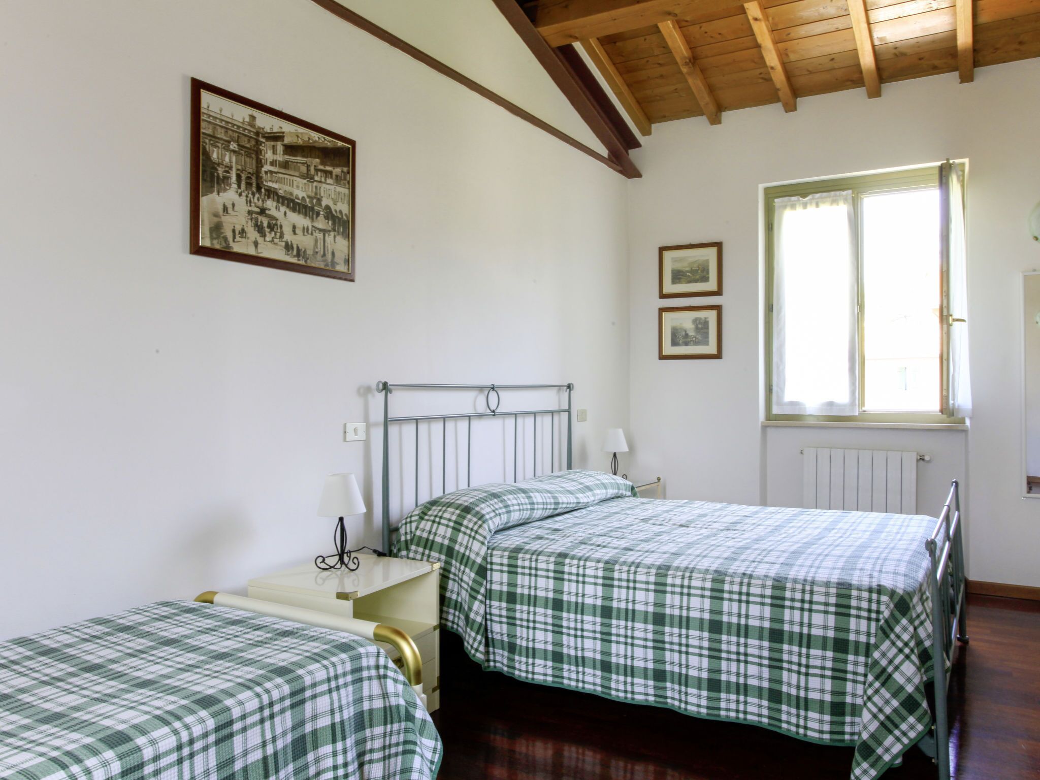 A room with two beds, a window, and a radiator.