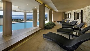 A modern indoor pool area with lounge chairs and a view of the sea. - Poiano Resort Appartamenti by Interhome (Garda)