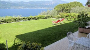 Une terrasse avec vue sur un lac et des montagnes.