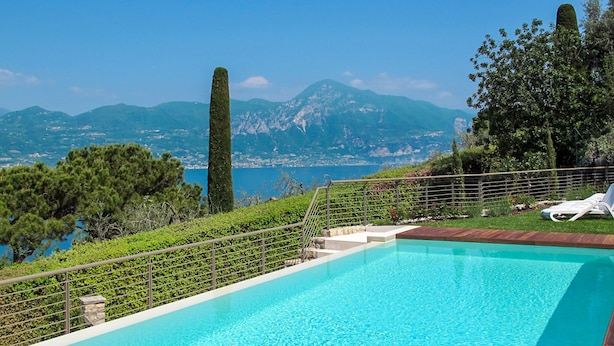 Une piscine avec vue sur les montagnes et la mer.