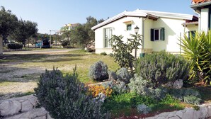 Une maison à deux étages avec un jardin à l’avant.