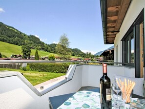 A balcony with a table, a bottle of wine, and a glass. - Vom Gerslosstein zum Rumerblick by Interhome (Aschau im Zillertal)