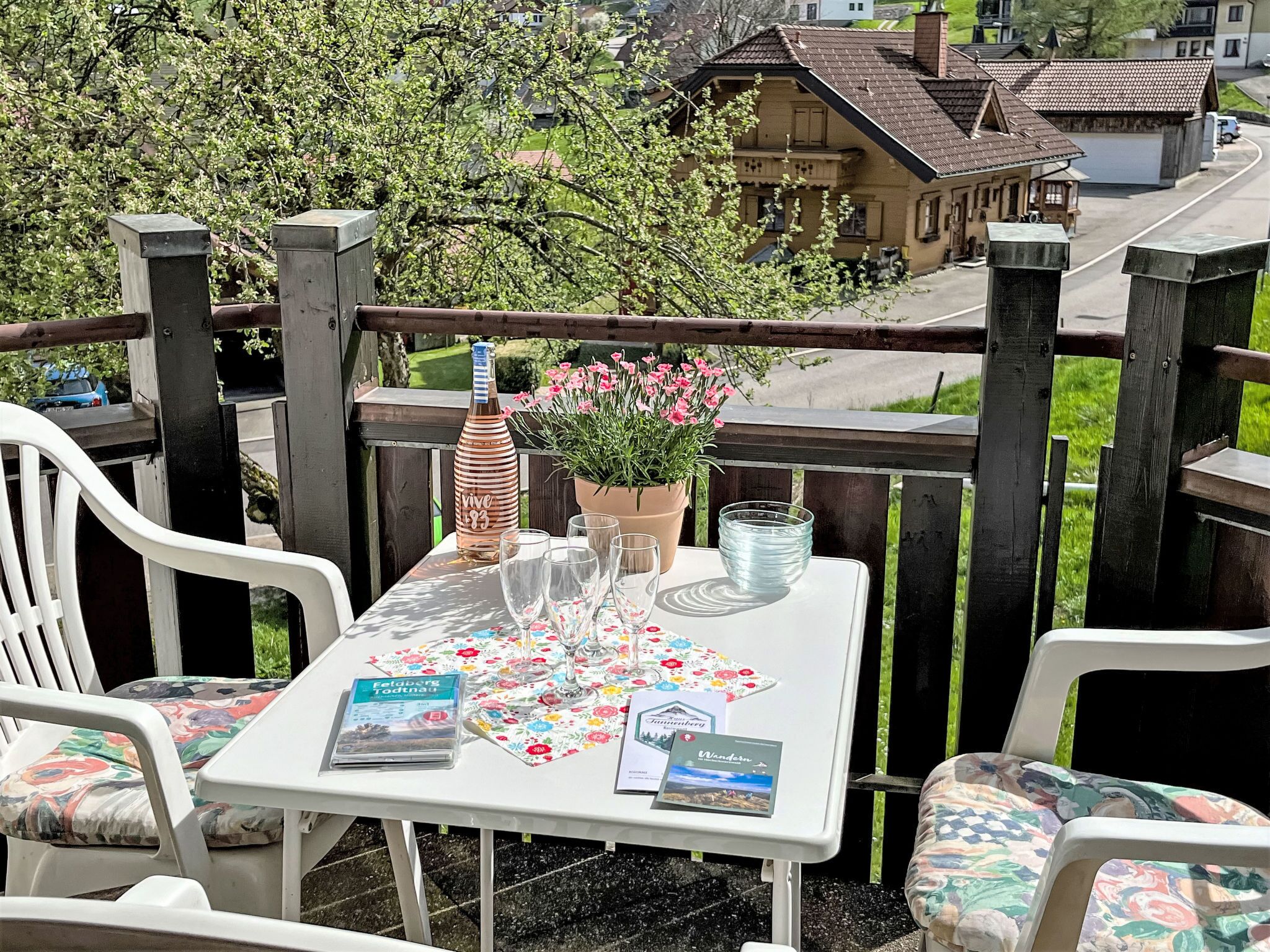 Een tafel buiten, met uitzicht op een huis en bomen.