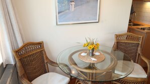 A dining area with wicker chairs, a glass table, and a framed painting on the wall. - Landhaus Mahnhamm by Interhome (Horumersiel)