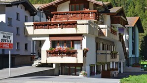 Un hôtel doté d’un balcon, d’une enseigne Coca-Cola et surplombant une chaîne de montagnes.
