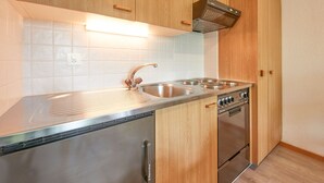 Een moderne keuken met houten kastjes, een roestvrijstalen spoelbak en een inbouwoven.