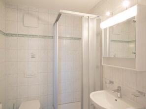 A bathroom with a shower, toilet, and sink.