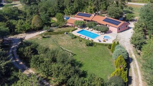 A residential property with a swimming pool, solar panels, and a well-maintained garden.