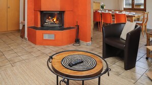 A living room with a fireplace, a dining area, and a seating area. - Edelweiss by Interhome (La Tzoumaz)