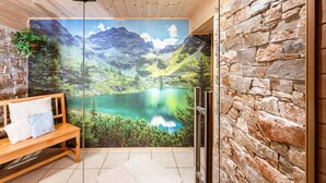 A room with a wooden bench, a stone wall, and a mural of a mountain lake. - Simons Blockhütte by Interhome (Gröbming)