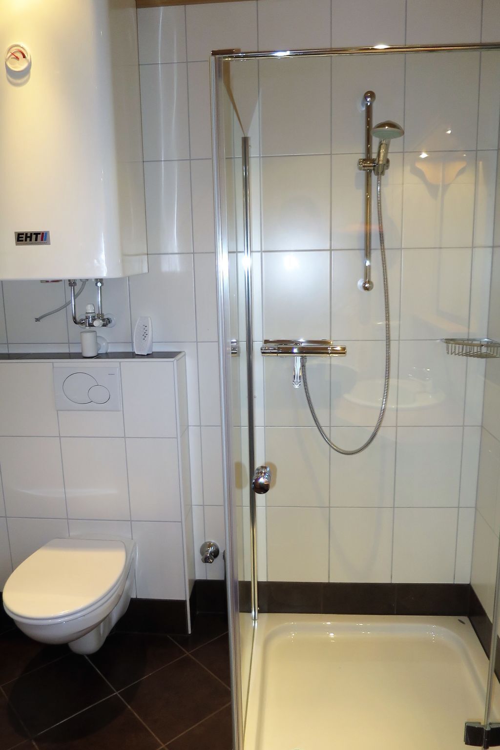 Ein modernes Badezimmer mit einer Duschkabine, einer Toilette und einer Badewanne.