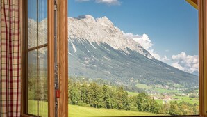 Una ventana con vistas a una montaña y un pueblo.