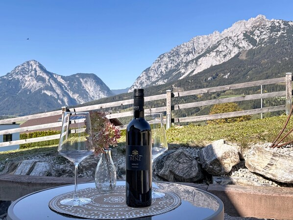 Una botella de vino sobre una mesa con vistas a las montañas.