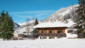 A snow-covered mountain village with a wooden chalet featuring balconies and a snow-covered roof. - Dr. Otto Schuler by Interhome (Sankt Anton am Arlberg)