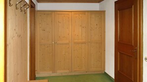 A room with a wooden wardrobe, a bench, and a green carpet. - Dr. Otto Schuler by Interhome (Sankt Anton am Arlberg)