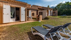 Una villa con un patio, mobiliario exterior y vistas del paisaje circundante.