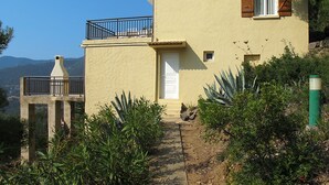 A two-story building with a balcony, a chimney, and a door. - Camelia- Marjolène by Interhome (Partinello)